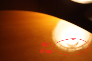 Slight ribbing in guitar top. Visible in reflected light.